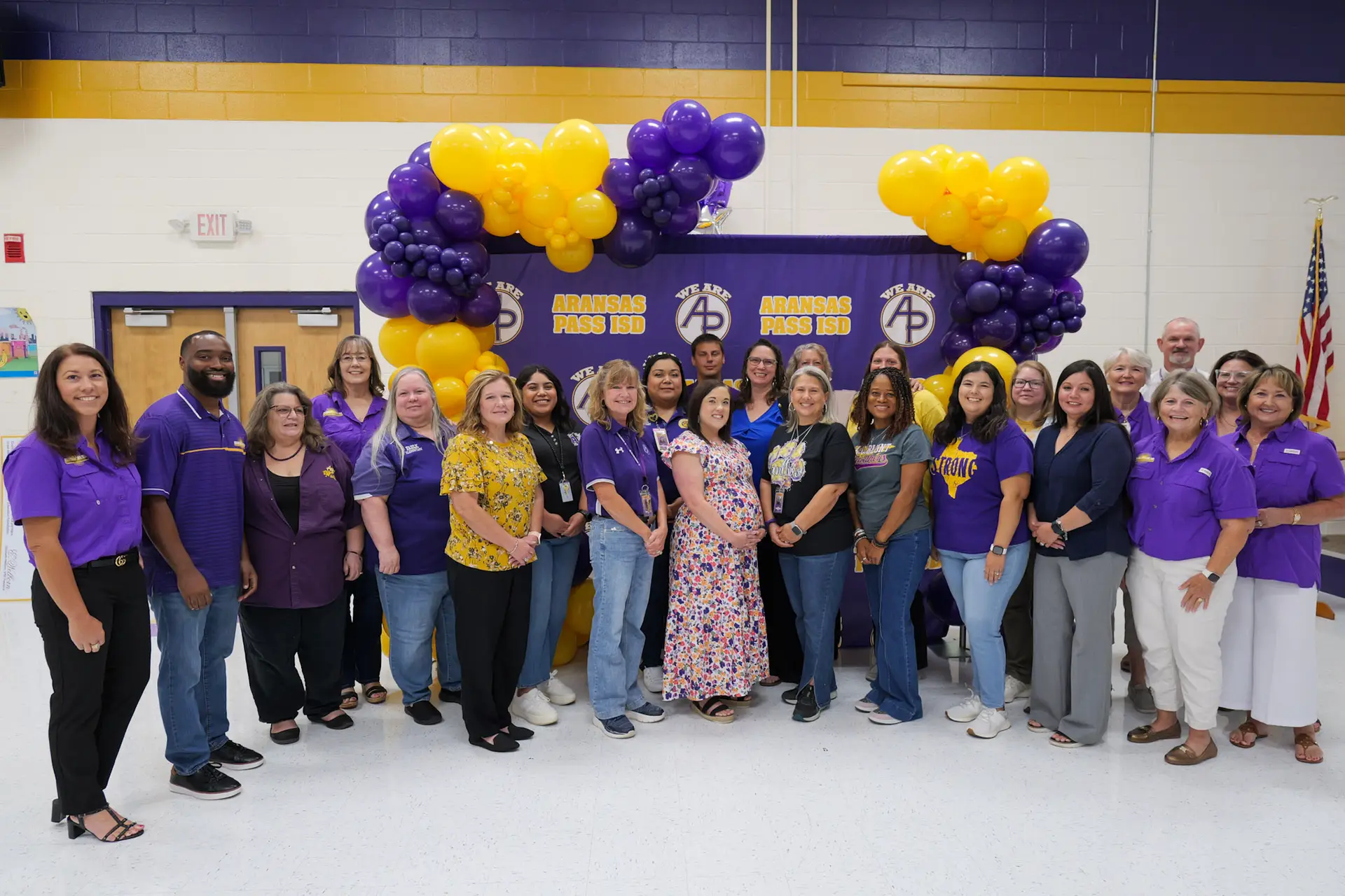 A picture of the Education foundation members standing in front of a purple AP backdrop